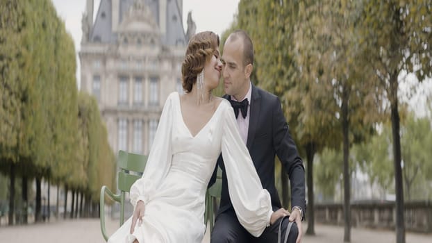 Beautiful elegant couple in suit and long dress posing outdoors in a city park. Action. Bride and groom on their wedding photosession