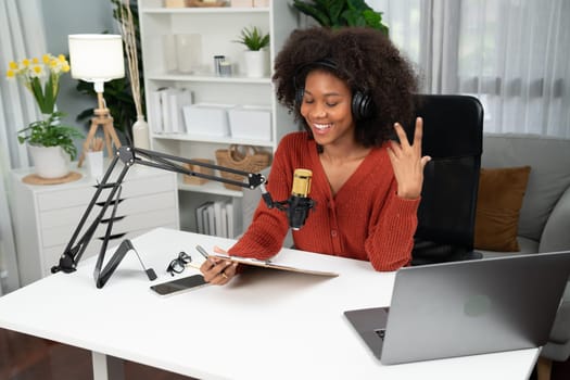 Host channel of beautiful African woman talking in online broadcast teaching marketing influencer, with listeners in broadcast or online. Concept of anywhere at work place. Tastemaker.