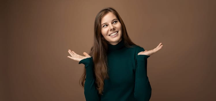 Attractive young woman with healthy brown hair on a brown background with copy space.