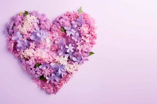 Multicolored flowers are laid out in the shape of a heart on a lilac background. The copy space. Minimalism.