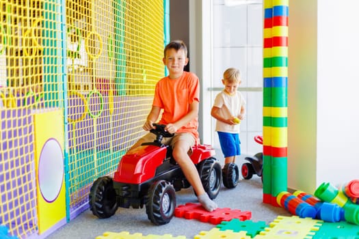 A child rides a toy pedal car at a children's play center.