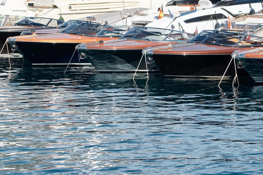 Few luxury retro motor boats in row at the famous motorboat exhibition in the principality of Monaco, Monte Carlo, the most expensive boats for the richest people, boats for rich clients. High quality photo