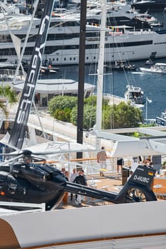 Monaco, Monte Carlo, 28 September 2022 - Rich clients visitors examine a helicopter standing on the deck of a yacht club, the largest fair yacht show, port Hercules, yacht brokers, sunny weather. High quality photo