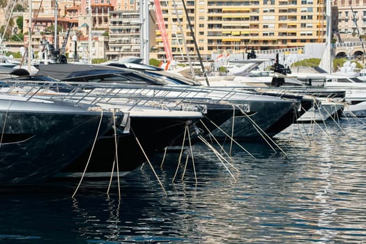 Sun glare on glossy board boats, azure water, tranquillity in port Hercules, bows of moored boats at sunny day, megayachts, Monaco, Monte-Carlo. High quality photo