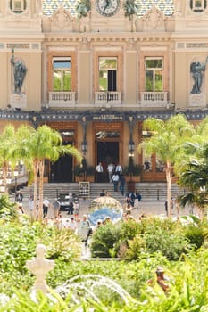 Monaco, Monte-Carlo, 28 September 2022 - Square Casino Monte-Carlo at sunny day, wealth life, tourists take pictures of the landmark, pine trees, blue sky. High quality photo