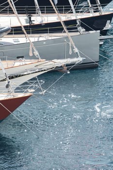 Sun glare on glossy board boats, azure water, tranquillity in port Hercules, bows of moored sailing boats at sunny day, megayachts, Monaco, Monte-Carlo. High quality photo