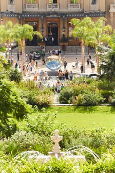 Monaco, Monte-Carlo, 28 September 2022 - Square Casino Monte-Carlo at sunny day, wealth life, tourists take pictures of the landmark, pine trees, blue sky. High quality photo