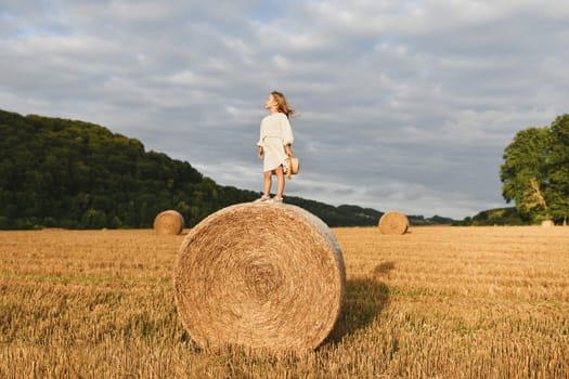 A girl on a bale of wheat Countryside