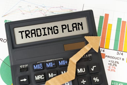 Business concept. On the business charts there is a calculator on the screen with the inscription - TRADING PLAN