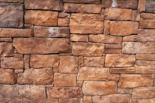 Background of an old wall made of red stone. Close-up, wall texture.