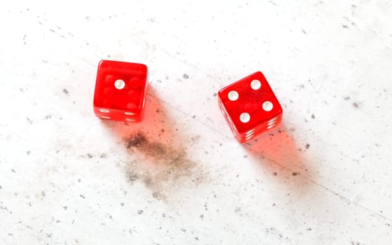 Two red craps dices showing Five (Fever 5) (Number 1 and 4) overhead shot on white board