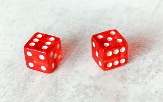 Two translucent red craps dices on white board showing Yo (Yo-leven) (number 6 and 5)