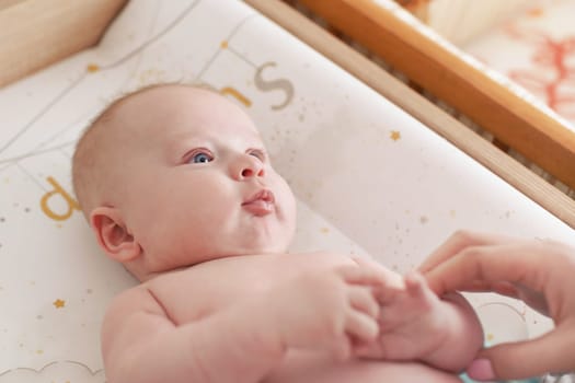 Photo of 3 months old infant baby boy, changing after bath, blurred mother hands in corner