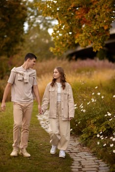 Young Cute Female Hugs Boyfriend. In Autumn Outdoor. Lovers Walking in Park. Attractive Funny Couple. Lovestory in Forest. Man and Woman. Cute Lovers in the Park. Family Concept. Happy Couple.