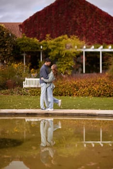 lovely young couple kissing outdoors in autumn. Loving couple walking in nature. Autumn mood. Happy man and woman hugging and kissing in autumn. Love. Fashionable couple outdoors. Fashion, people and lifestyle. Stylish couple in autumn outfit.