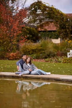 lovely young couple kissing outdoors in autumn. Loving couple walking in nature. Autumn mood. Happy man and woman hugging and kissing in autumn. Love. Fashionable couple outdoors. Fashion, people and lifestyle. Stylish couple in autumn outfit.