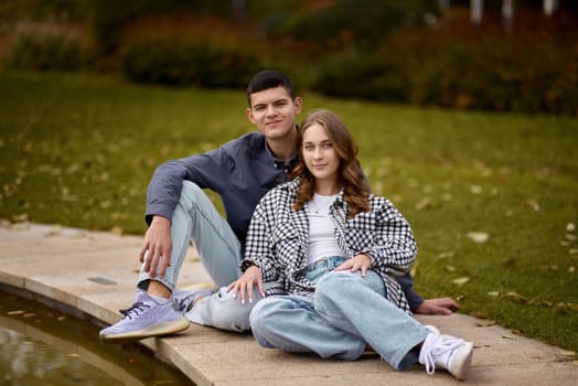 lovely young couple kissing outdoors in autumn. Loving couple walking in nature. Autumn mood. Happy man and woman hugging and kissing in autumn. Love. Fashionable couple outdoors. Fashion, people and lifestyle. Stylish couple in autumn outfit.