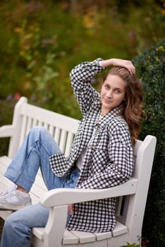 Charming Autumn Casual: Beautiful Girl on Park Bench.