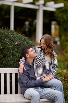 lovely young couple kissing outdoors in autumn. Loving couple walking in nature. Autumn mood. Happy man and woman hugging and kissing in autumn. Love. Fashionable couple outdoors. Fashion, people and lifestyle. Stylish couple in autumn outfit.