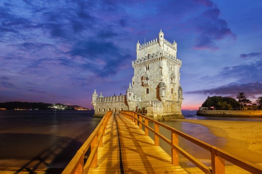 Belem Tower or Tower of St Vincent - famous tourist landmark of Lisboa and tourism attraction - on the bank of the Tagus River (Tejo) after sunset in dusk twilight with dramatic sky. Lisbon, Portugal