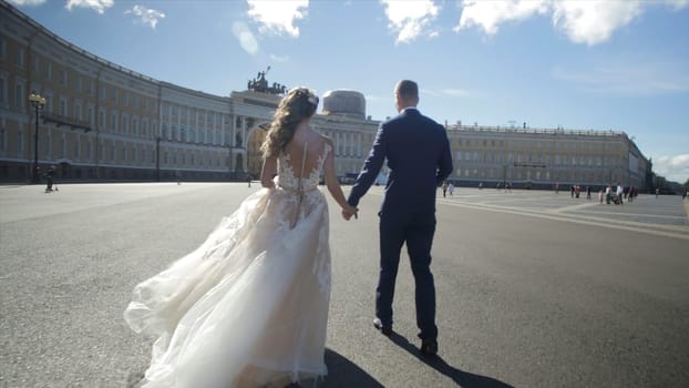 St Petersburg, Russia Bride and groom walking along. the bride and groom walk on the square near the winter Palace and holding hands. Bride and groom holding hands walk on square of Saint Petersburg HD