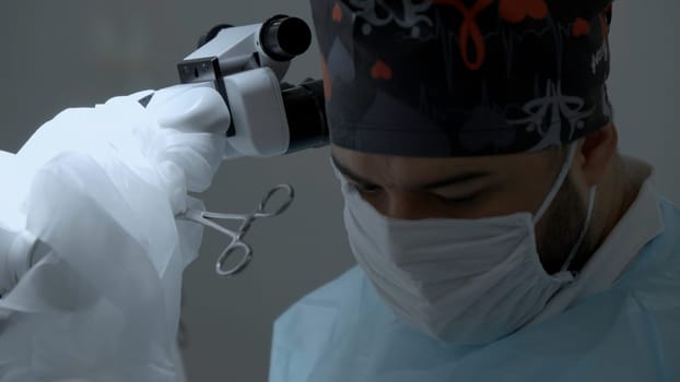 Medical worker performing surgery. Action. Concept of health care and medicine, doctor standing by microscope