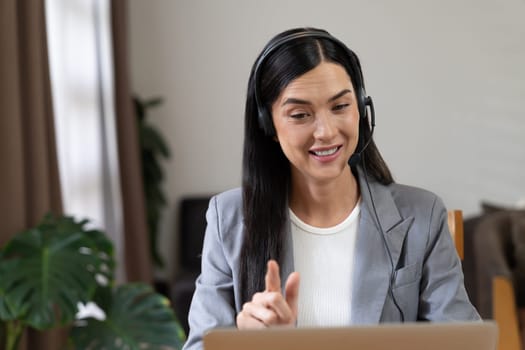 Female call center operator or customer service helpdesk staff working on workspace while talking on the headset to provide assistance for customer. Professional modern business service. Blithe