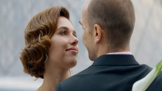 Portrait of an attractive couple, woman with red curly hair and a man in suit. Action. Loving man and woman embracing, smiling lady