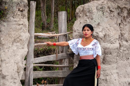 indigenous woman at the door of her house wearing traditional dress of her ecuadorian culture. High quality photo