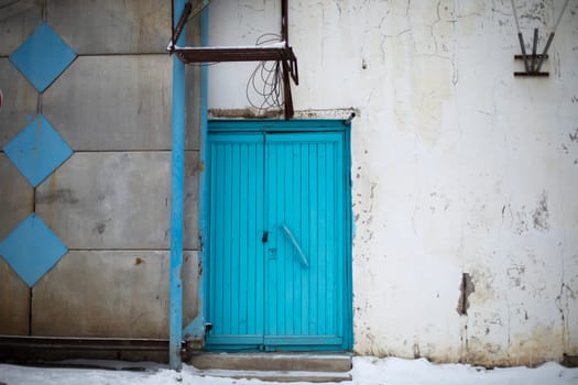 Blue door. Old door to building. Back entrance. Industrial purpose. Details of house.