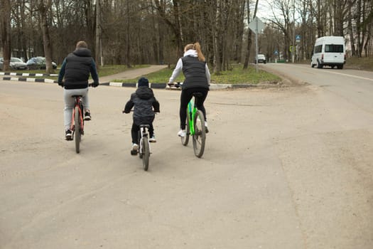 Family on bikes. Cycling. People on road. Family in city.
