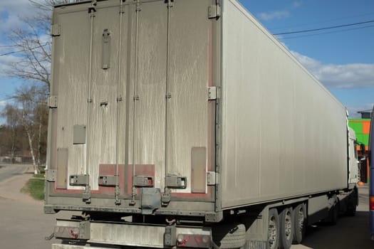 Truck. Large body. Transportation of goods. Dirty truck body. White bodywork.