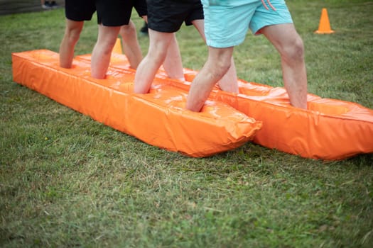 Sports game. Group competition. Orange Material. Athletes legs.