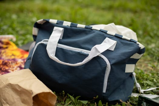 Bag for things. Duffel bag in park. Things on picnic. Wardrobe item.