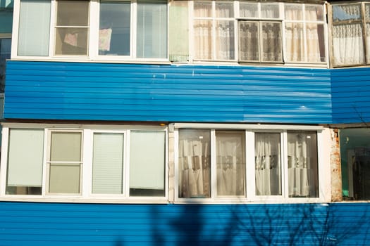 Blue balconies of house. Places to stay in city. Facade of building. Details of old urban development.