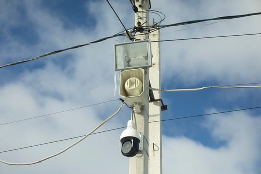 Surveillance camera on the pole. Outdoor Loudspeaker. Spotlight on a pole. City Surveillance System.