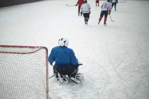 Hockey player defends goal. Goalie on ice. Playing hockey. Winter sports competition.