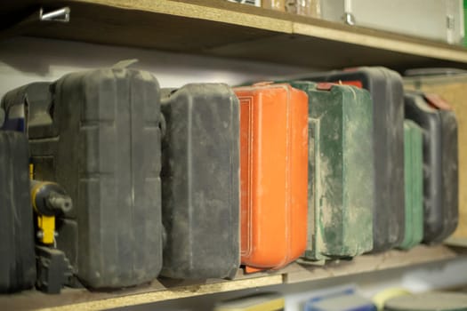 Tool boxes. Boxes with insert on shelf. Things in garage.