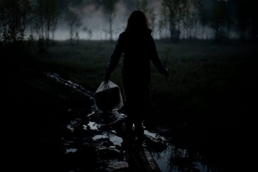 Girl walks in fog in morning. Rest in wild. Fog in swamp. Man carries things to water.