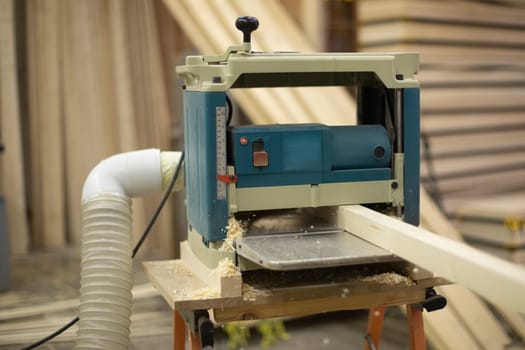 Cutting board in wood workshop. Processing of wood bar. Sawing off layer. Tool in workshop.