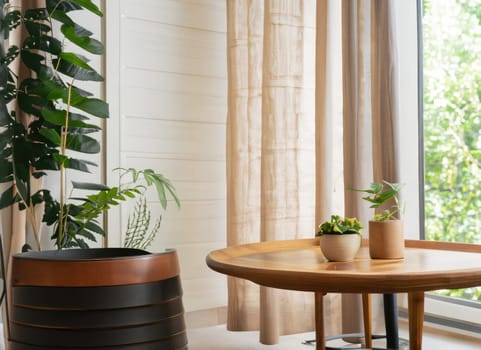 chair and round wooden coffee table against window near paneling wall