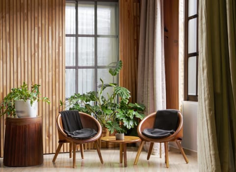 chair and round wooden coffee table against window near paneling wall