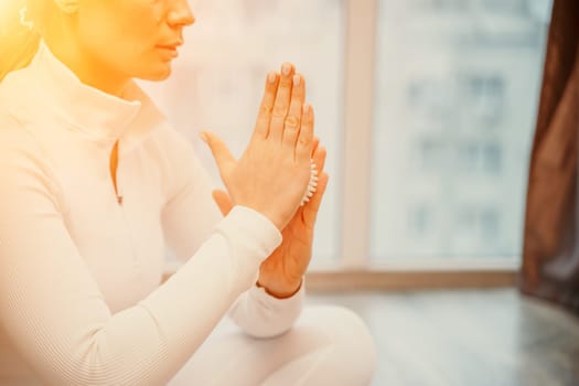 Athletic slim caucasian woman doing thigh self-massage with a massage ball indoors. Self-isolating massage.