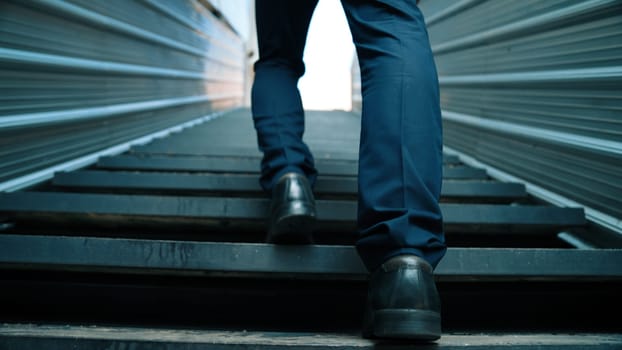 Closeup image of successful business man leg walking up to stair. Project manager changing workplace, discover a new thing, growth or getting promotion or walking in to light. Rising up. Exultant.