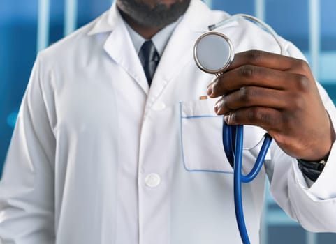 medical team working at modern clinic while pandemic, cropped of two women in white coats doctors holding syringe and stethoscope