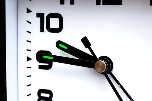 Black hands of a clock on a white dial close up, copy space