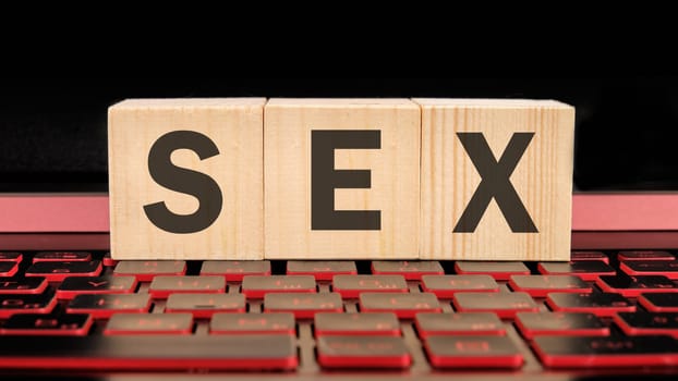 sex written on wooden cubes on the laptop keyboard