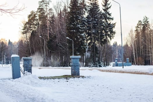 Metal buildings and steam in the winter on forest background