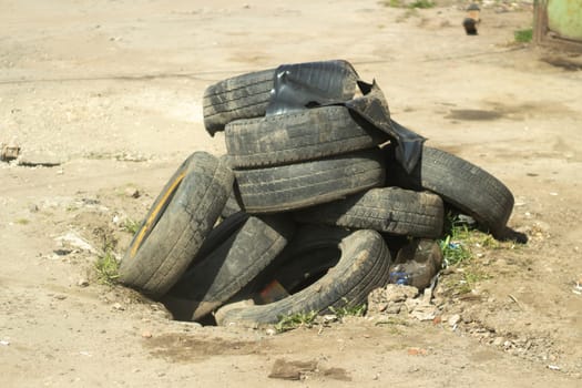 Tires from car. Used wheels. Rubber warehouse. Abandoned car parts.