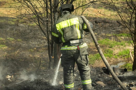 Lifeguard on duty. Firefighter puts out fire. Details of fire. Rescuer in Russia. Extinguishing fire in forest.